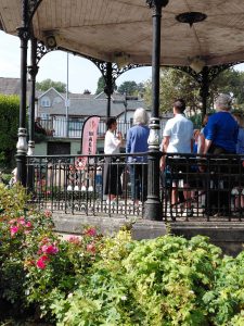 Grange over Sands bandstand on a sunny summer day with The Growing Singers performing for a gathered crowd, even closer up photo