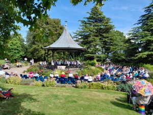 Grange over Sands bandstand on a sunny summer day with The Growing Singers performing for a gathered crowd